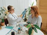 A woman receives a blood pressure check from a doctor in a clinical setting, focusing on health and wellness.